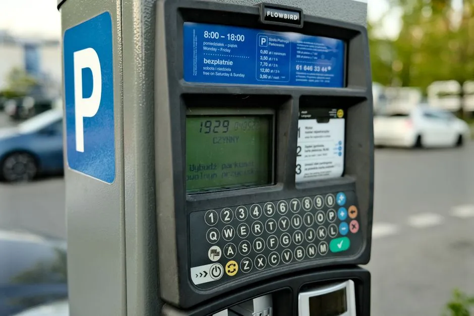 A curbside parking meter in a city, illustrative of the type of signage and payment terminals drivers encounter